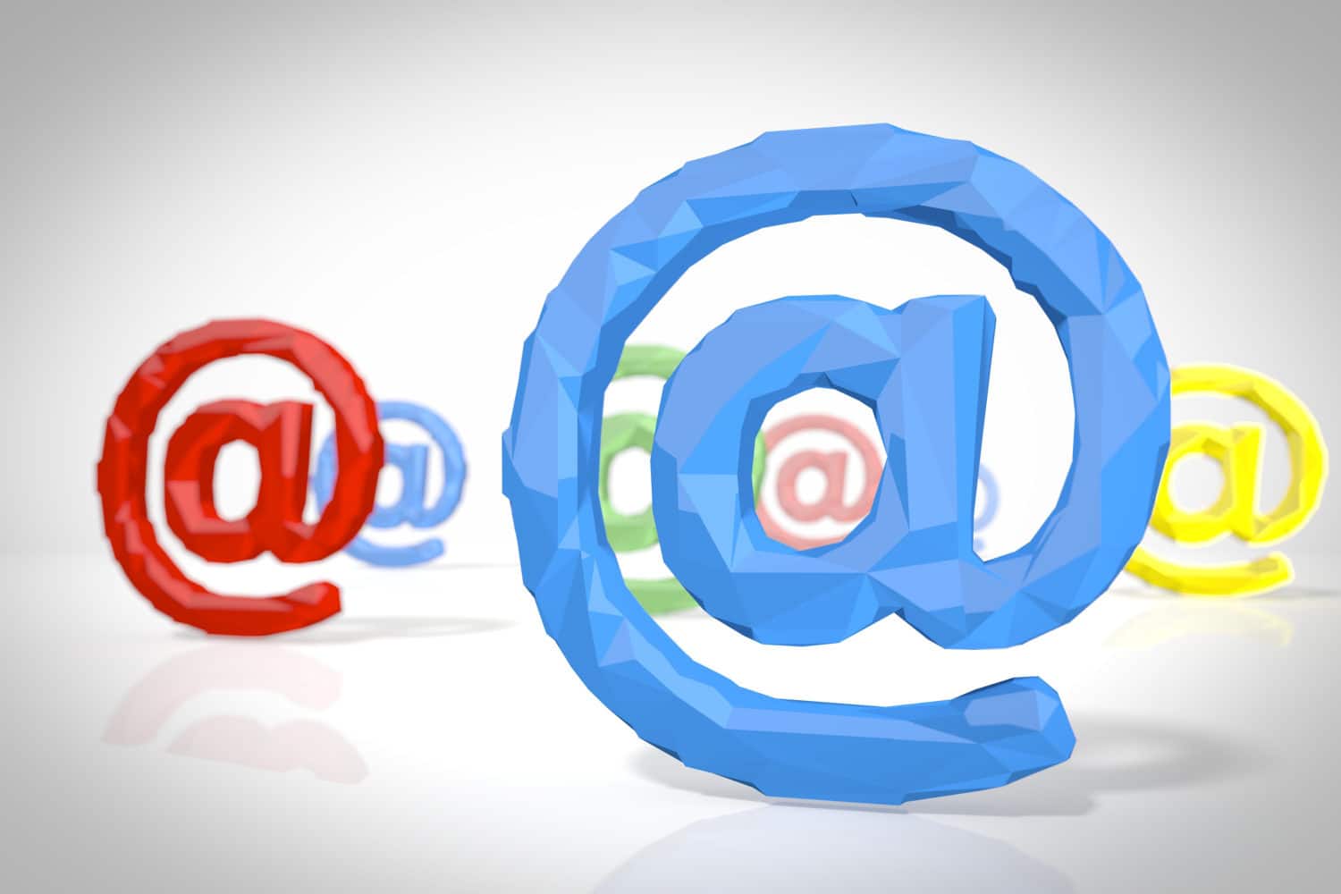 Das Bild zeigt mehrere @-Zeichen, wie man sie in E-Mail-Adressen üblicherweise benutzt. Die Zeichen sind rot, blau, grün und gelb und dreidimensional im Raum angeordnet.