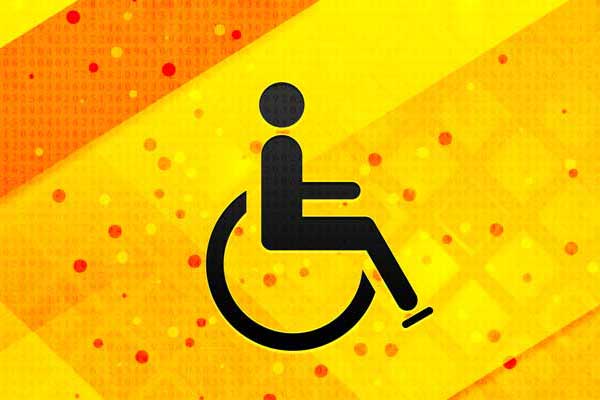 Vor einem gelb-orangenen Hintergrund befindet sich ein schwarzes Icon: Ein Strichmännchen sitzt in einem Rollstuhl. Dies ist ein Symbolbild